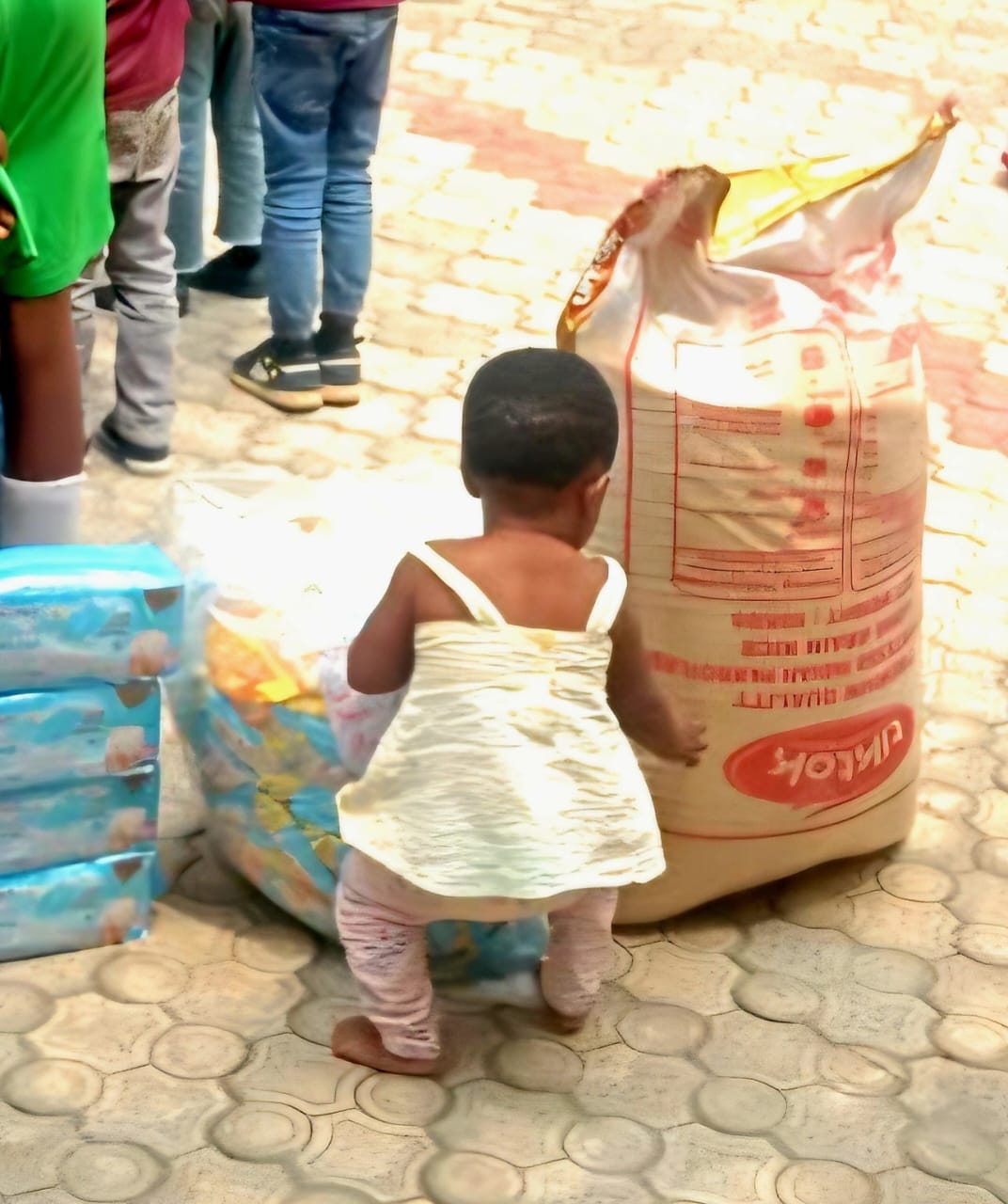 A child at God's Mercy Orphanage beside the donated items